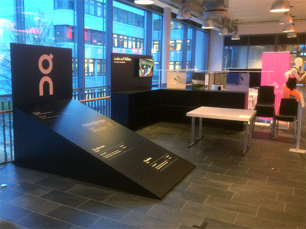 kleiner Messestand mit Regalen, Pr�sentern und schr�gem Podest