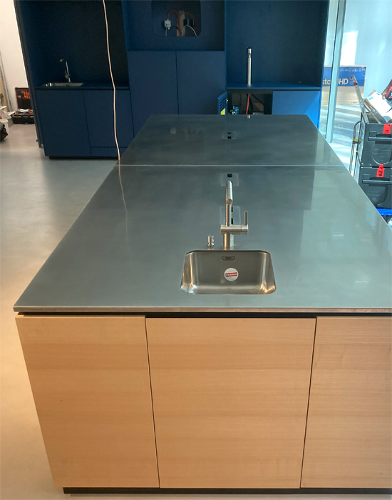 Objekteinrichtung Showk�che Vollkernarbeitsplatte, eingefr�stes Waschbecken r�ckseitig verklebt, M�llkipper aus Aluminium, Arbeitsplatte aus Edelstahl mit Kabelausschnitten